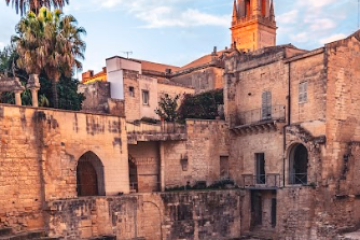 a stone castle next to a brick building