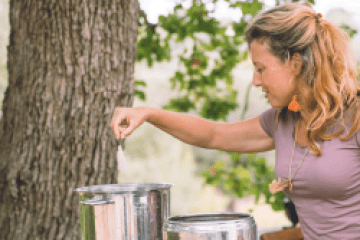a woman standing next to a tree
